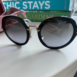 Miu Miu circular glasses in black and gold